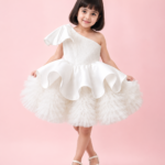 White one-shoulder princess party dress for girls with voluminous layered tulle skirt and elegant flared silhouette