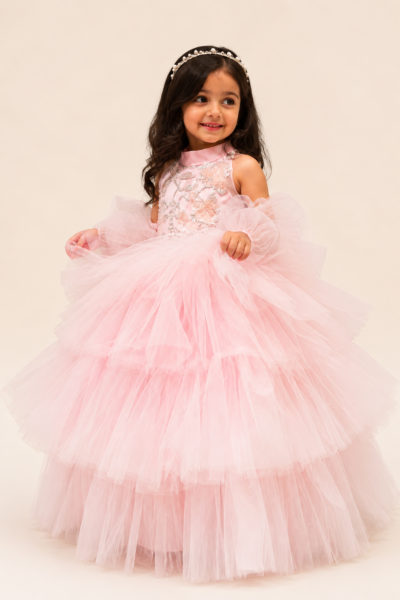 Beautiful little girl wearing a pink princess party dress with a voluminous tulle skirt and elegant pearl hairband, styled for a birthday, wedding or special occasion.